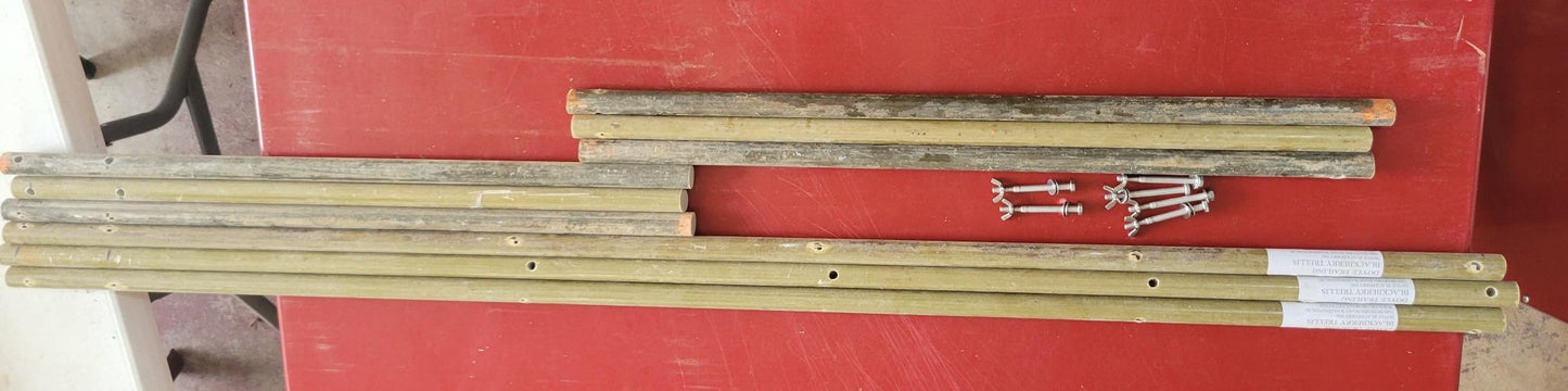 Doyle Trailing Blackberry Shift Trellis components, including fiberglass rods and screws on a red surface.