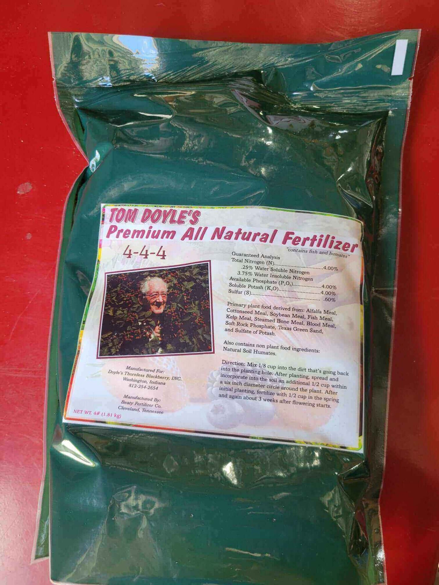 Tom Doyle's Premium All Natural 4-4-4 Fertilizer package for gardening, promoting healthy plant growth.